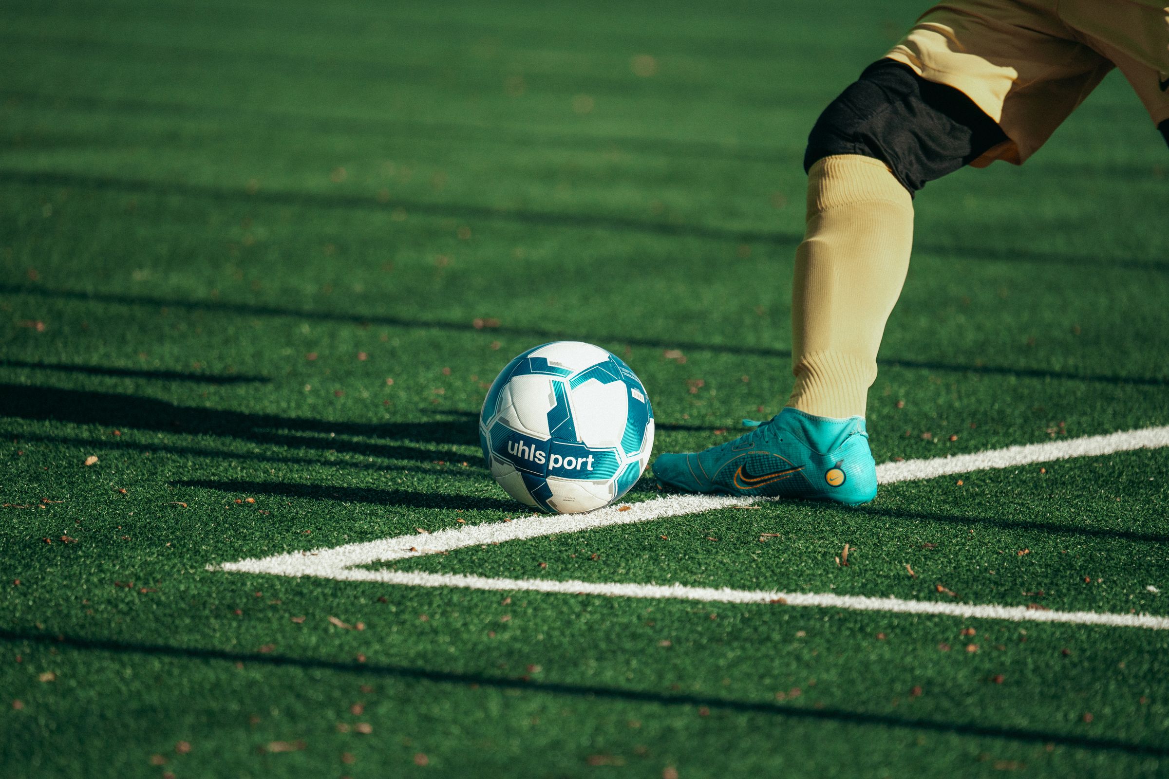 A player about to strike the ball on an artificial pitch