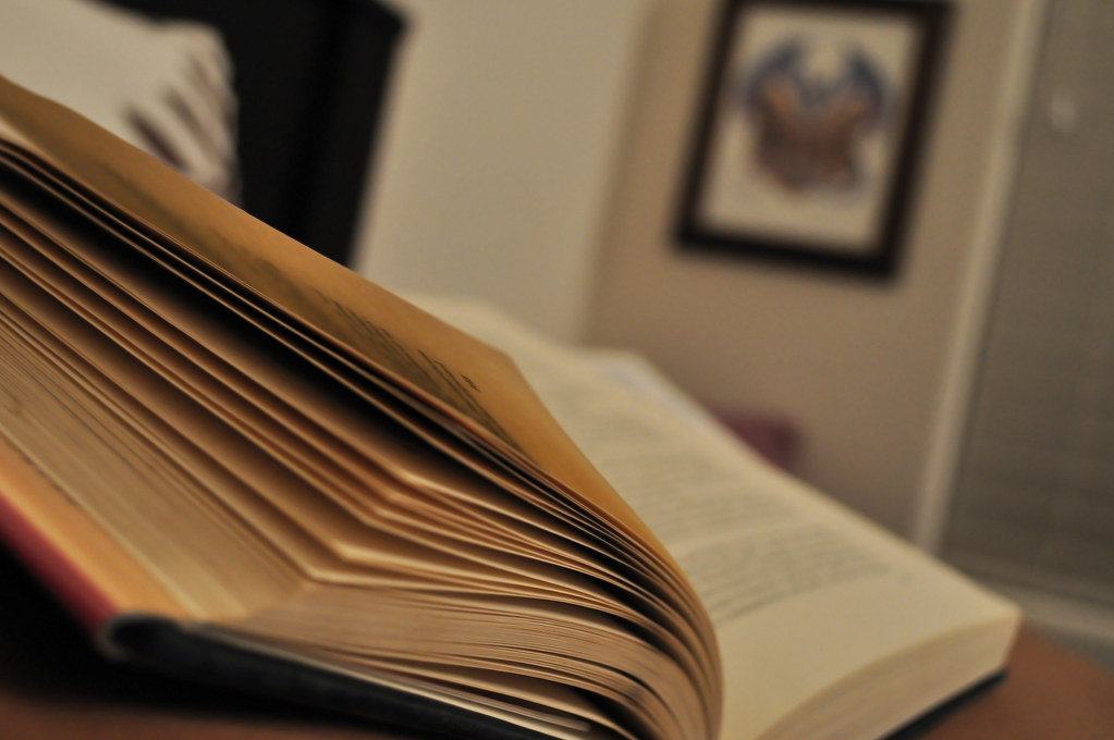 An open book, pages fanned, on a desk